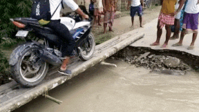 Biker ngã xuống dòng nước lũ khi đi qua cây cầu hẹp