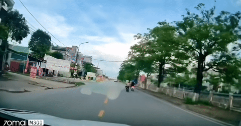 Người phụ nữ đi xe đạp điện tạt đầu xe kh&aacute;c, em b&eacute; ngồi sau ng&atilde; ngửa ra đường