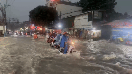 Nước chảy như thác cuốn ngã người đi xe máy ở TP HCM sau mưa lớn
