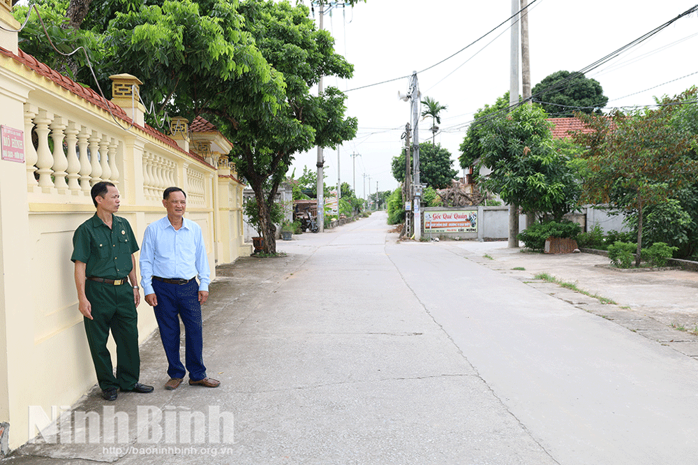 CCB Nguyễn Tiến Dũng (bên phải) tự nguyện hiến đất làm đường giao thông nông thôn.